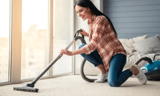 Lady vacuuming carpet floor | The Flooring Center