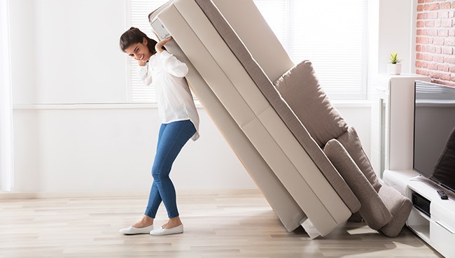 Woman Moving Sofa At Home | The Flooring Center