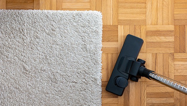 Vacuum cleaner extension on a laminated wooden floor | The Flooring Center