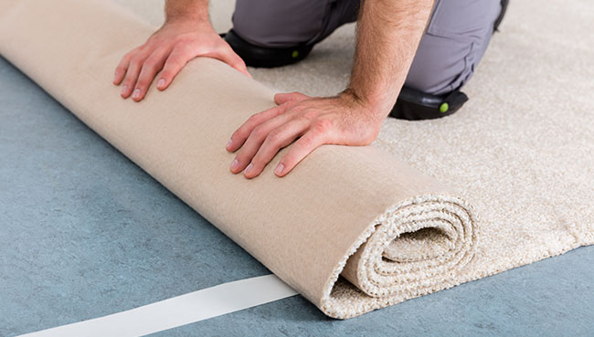 Man rolling carpet | The Flooring Center
